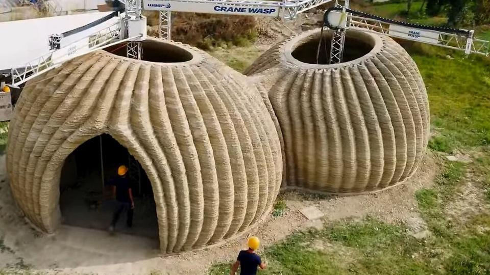 Two round clay homes built layer by layer by a large-scale 3D printer