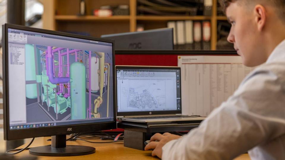 Engineer working on a CAD assembly across two monitors